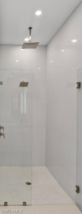 Bright interior space featuring large format tile flooring, a modern black ceiling fan, recessed lighting, and a window with a black frame