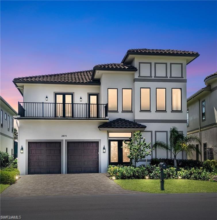 View of front of property featuring a balcony and a garage
