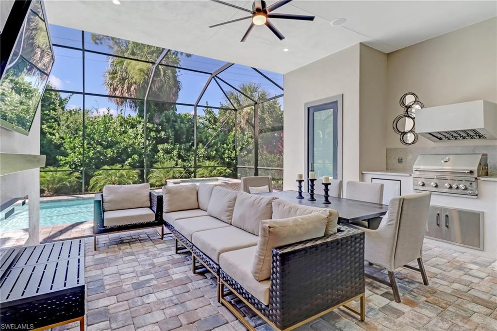 View of patio with an outdoor hangout area, a lanai, ceiling fan, exterior kitchen, and a grill
