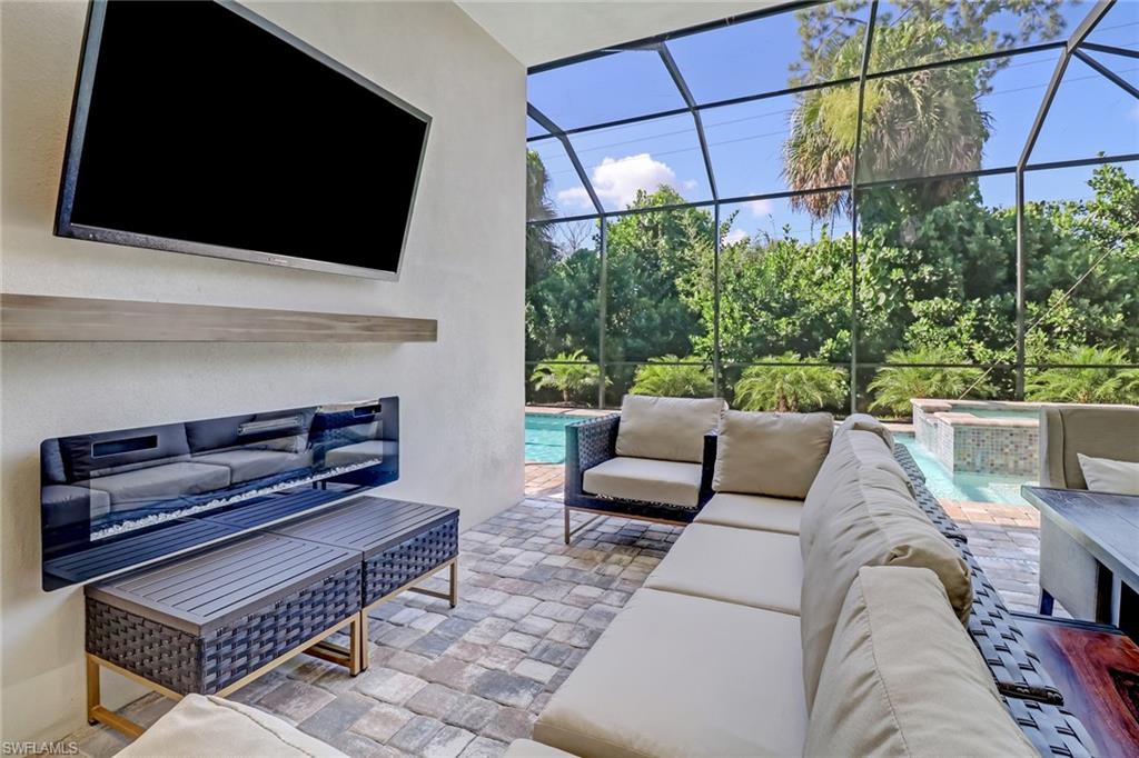 View of patio with a swimming pool with hot tub, an outdoor living space, and glass enclosure