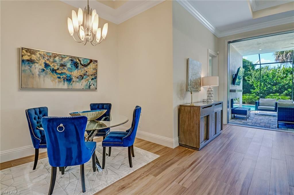 Dining room featuring light hardwood / wood-style floors, a chandelier, and ornamental molding