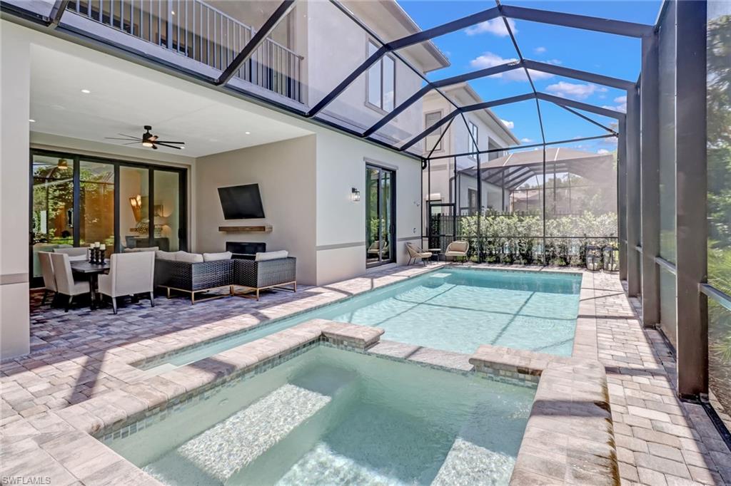 View of swimming pool featuring an outdoor living space, ceiling fan, a lanai, an in ground hot tub, and a patio