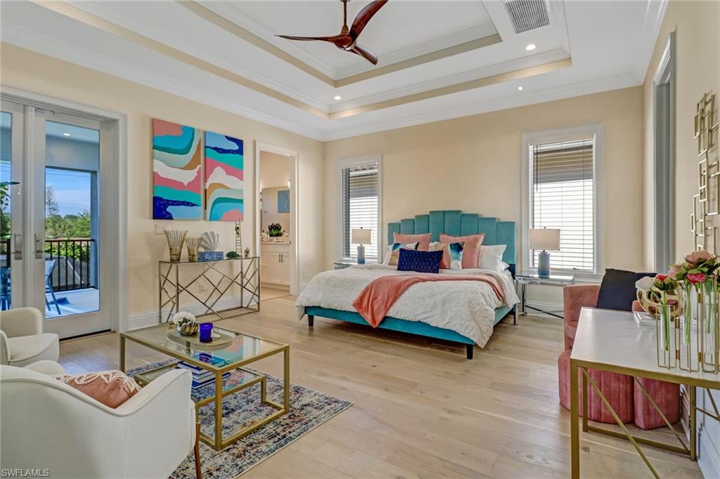 Bedroom featuring access to exterior, a tray ceiling, ceiling fan, crown molding, and light hardwood / wood-style flooring
