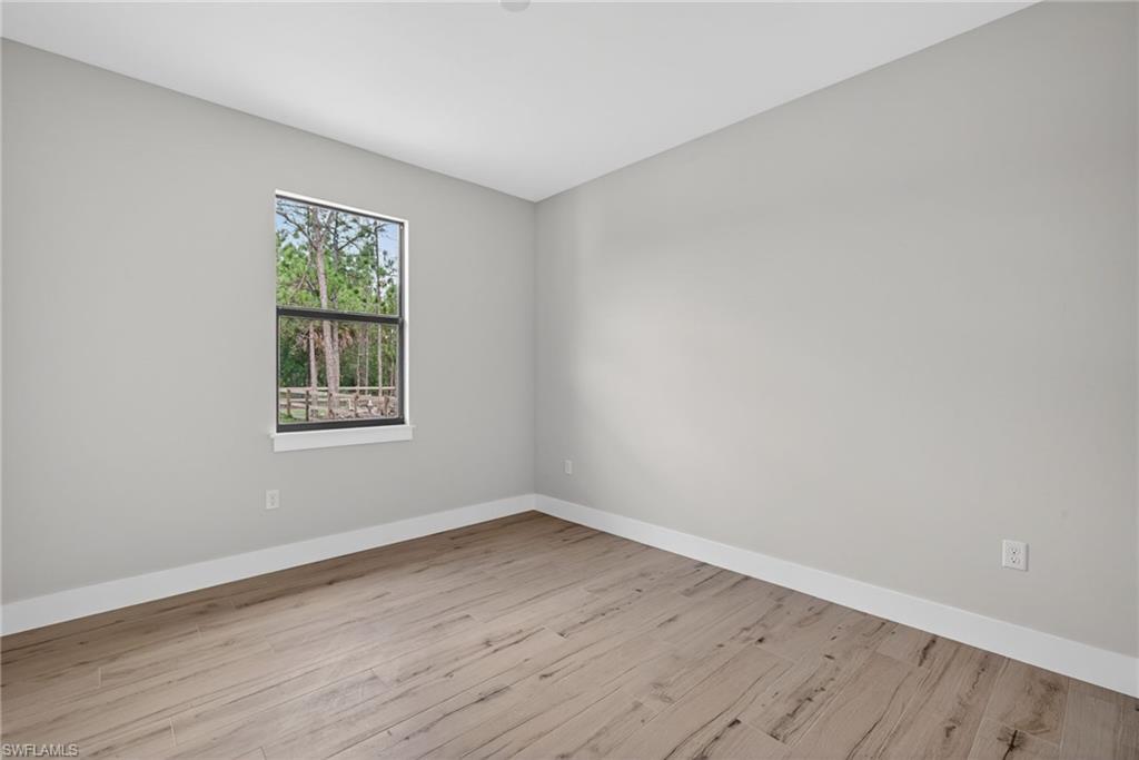 Interior room featuring light gray walls and wood-finish flooring