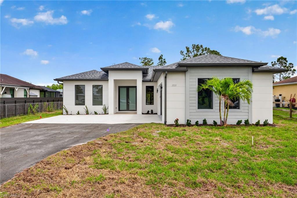 Contemporary single-story residence featuring a white stucco exterior with dark gray accents