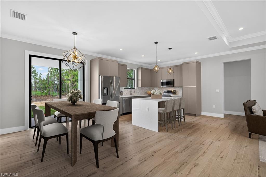 Contemporary kitchen featuring stainless steel appliances, an island with seating, and pendant lighting