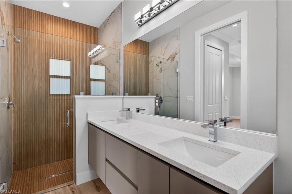 Contemporary bathroom featuring a dual vanity with integrated sinks and a spacious walk-in shower