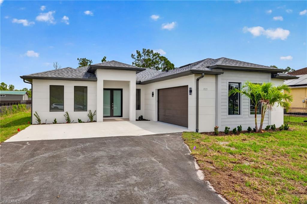 Contemporary single-story residence featuring a white stucco exterior and dark framed windows