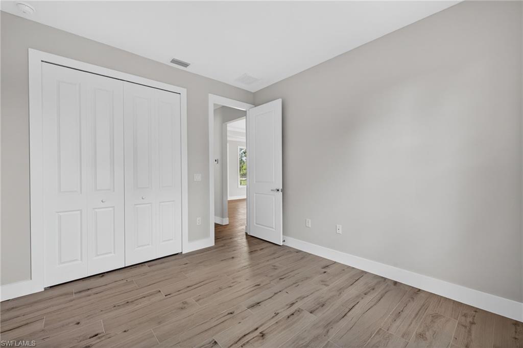 Room with light grey painted walls and wood-finish flooring