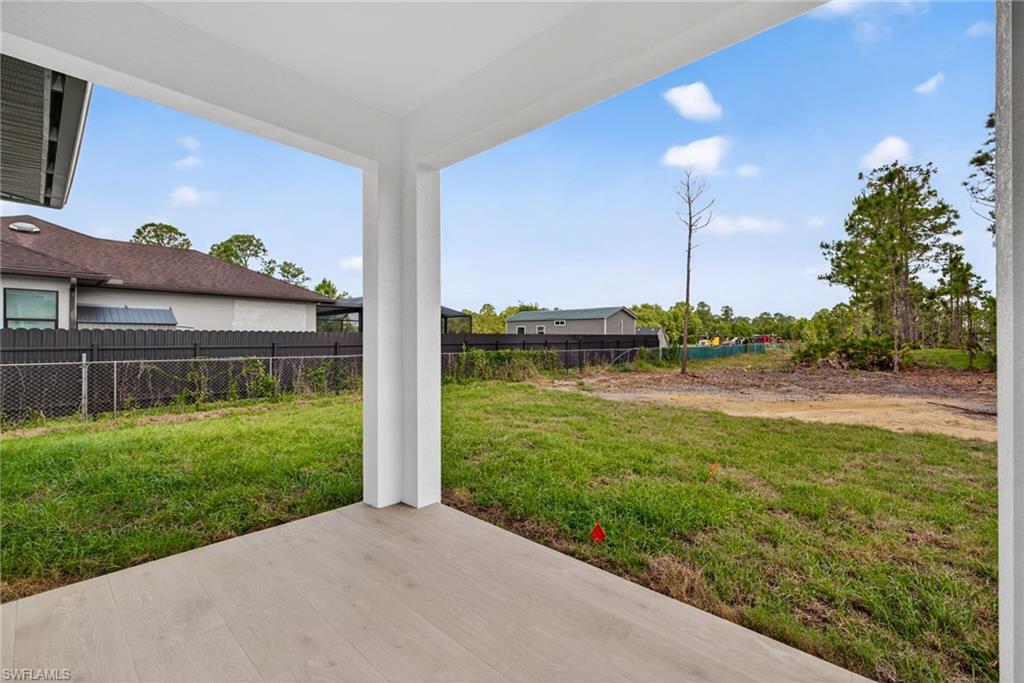Covered patio featuring pale wood-finish flooring and white support columns