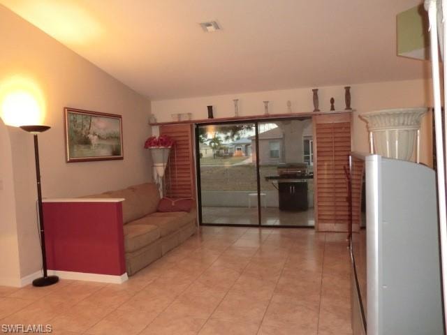 Open concept living area with vaulted ceilings and tile flooring