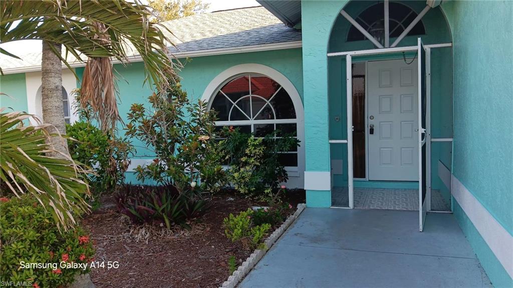 Turquoise exterior with white trim, arched windows, and a screened entry