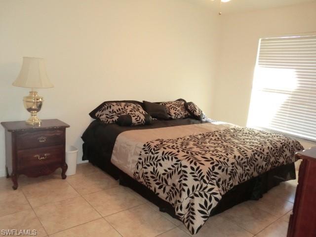 Neutral tone wall paint, tile flooring, window with horizontal blinds, and a ceiling fan with light fixture