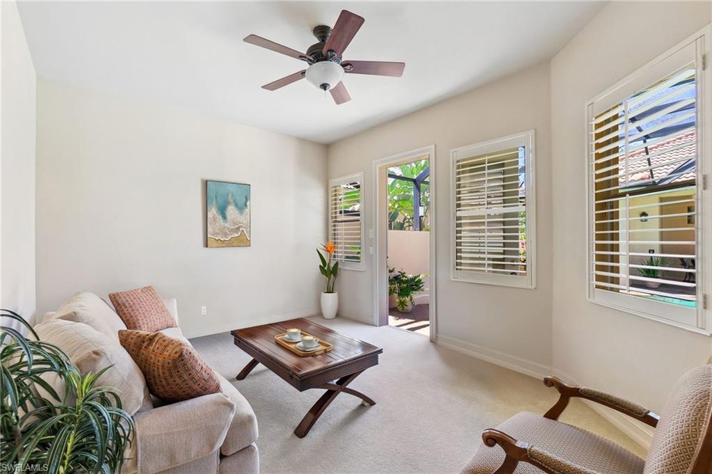 Living area with carpet flooring, baseboards, and a ceiling fan