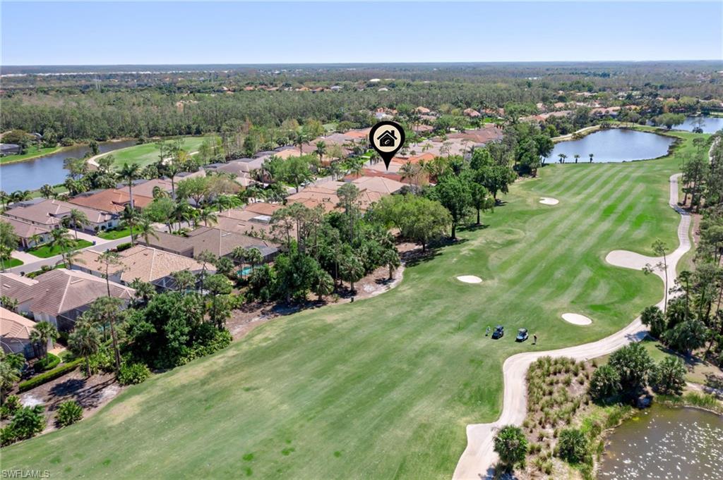 Birds eye view of property with a water view and view of golf course