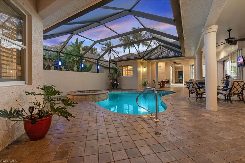 View of swimming pool with a patio area, a lanai, a pool with connected hot tub, and a ceiling fan