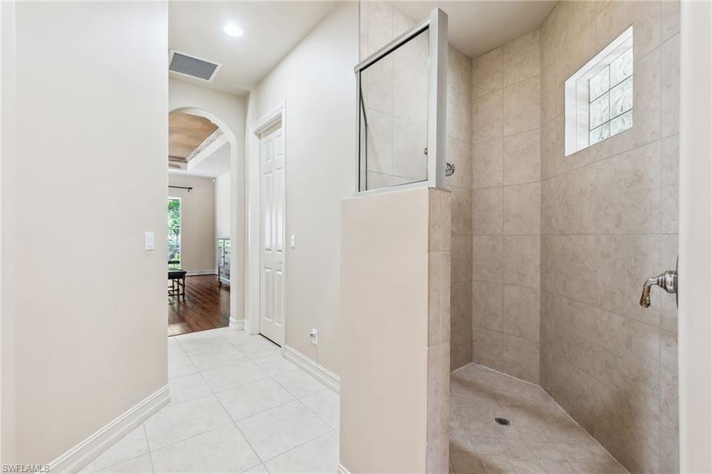 Full bath with tile patterned flooring, baseboards, visible vents, and walk in shower