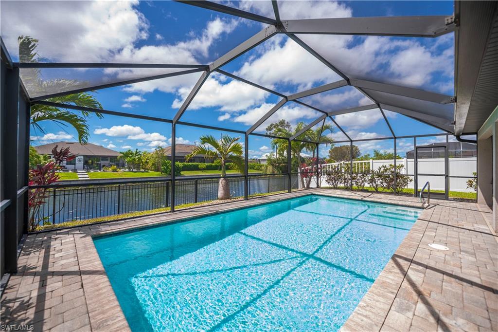 pool with pavers looking out to canal with fenced in area.