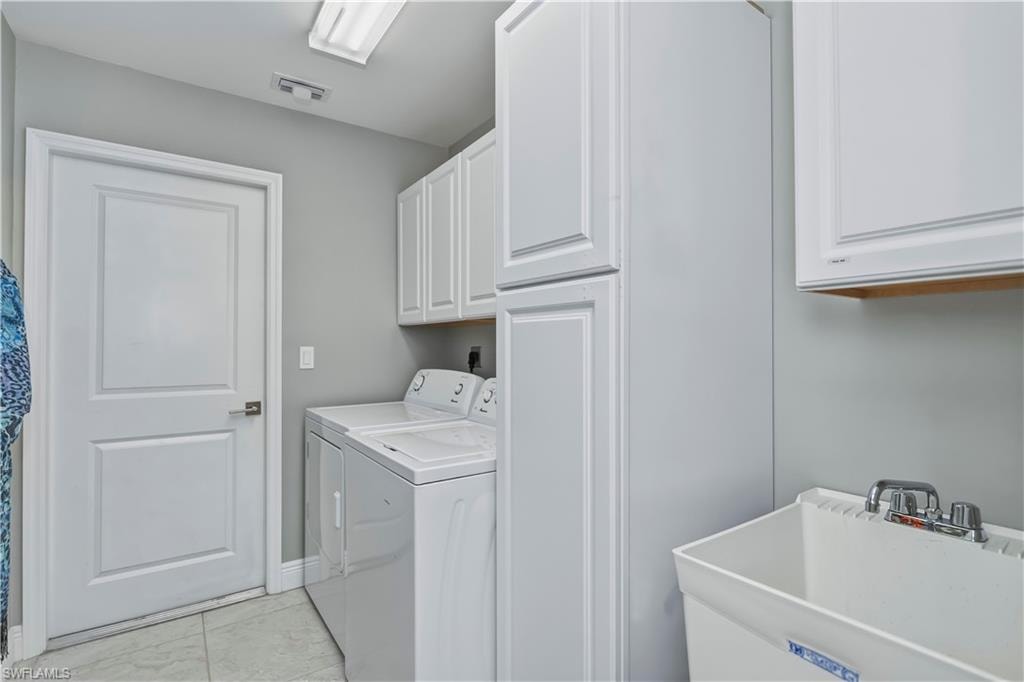 Inside Laundry room with sink and lots of cabinets for storage