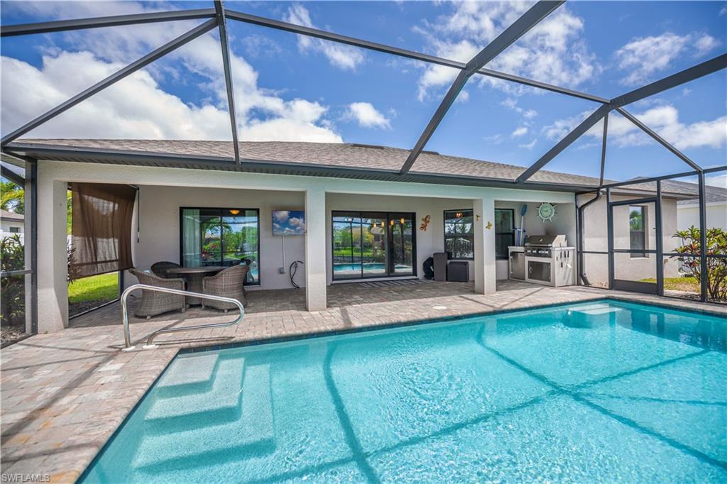 pool looking into lanai covered area  and outdoor kitchen