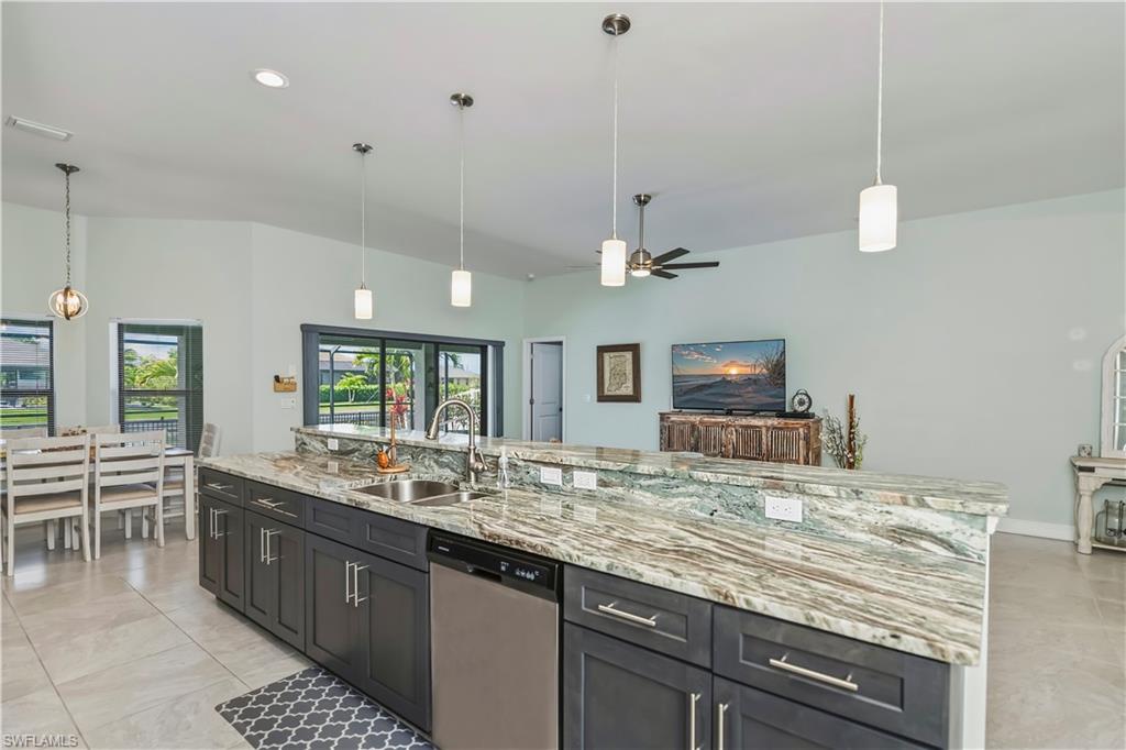 long granite kitchen island looking towards eat in kitchen area and slider to lanai
