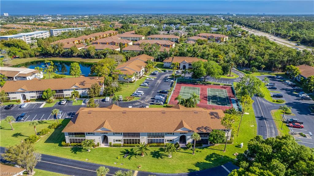 Aerial overview showcasing residential buildings with new(er) roofs, surrounded by mature trees.