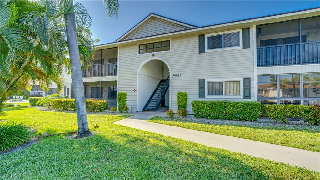 Low rise condo featuring light-colored siding, accented shutters, and screened balconies.