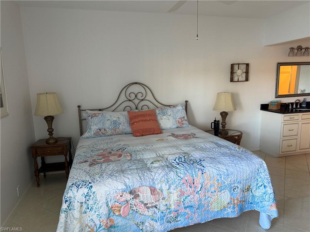 Bedroom with light tile patterned floors and a ceiling fan