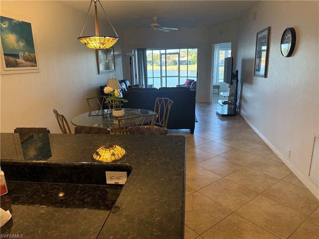 Dining room with light tile patterned floors and a ceiling fan