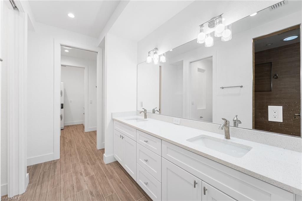 The primary ensuite bath showcases dual sparkling white quartz vanity countertops, a private water closet, and a spacious walk-in shower. Through the doors ahead, you’ll find a generous walk-in closet as well as a laundry room—conveniently accessible from both the primary suite and the main living area, offering ease for guests and family members alike.