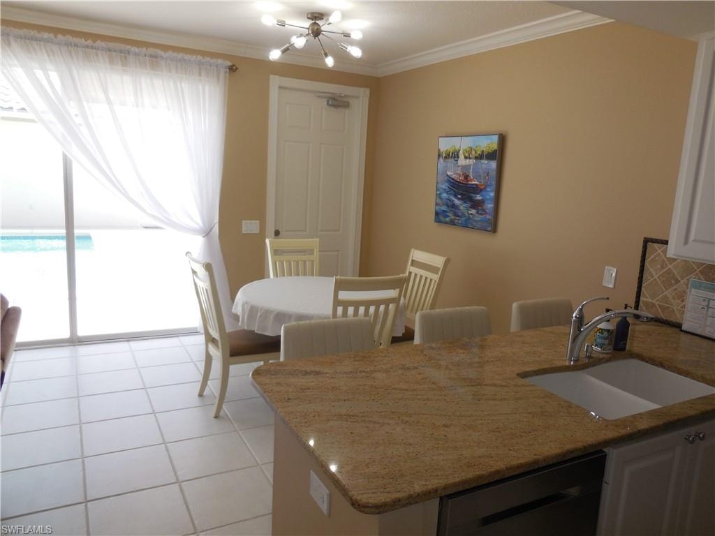 Dining area featuring crown molding, a chandelier, and light tile patterned floors