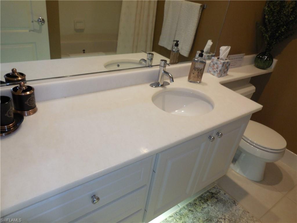 Bathroom featuring toilet, vanity, and tile patterned flooring