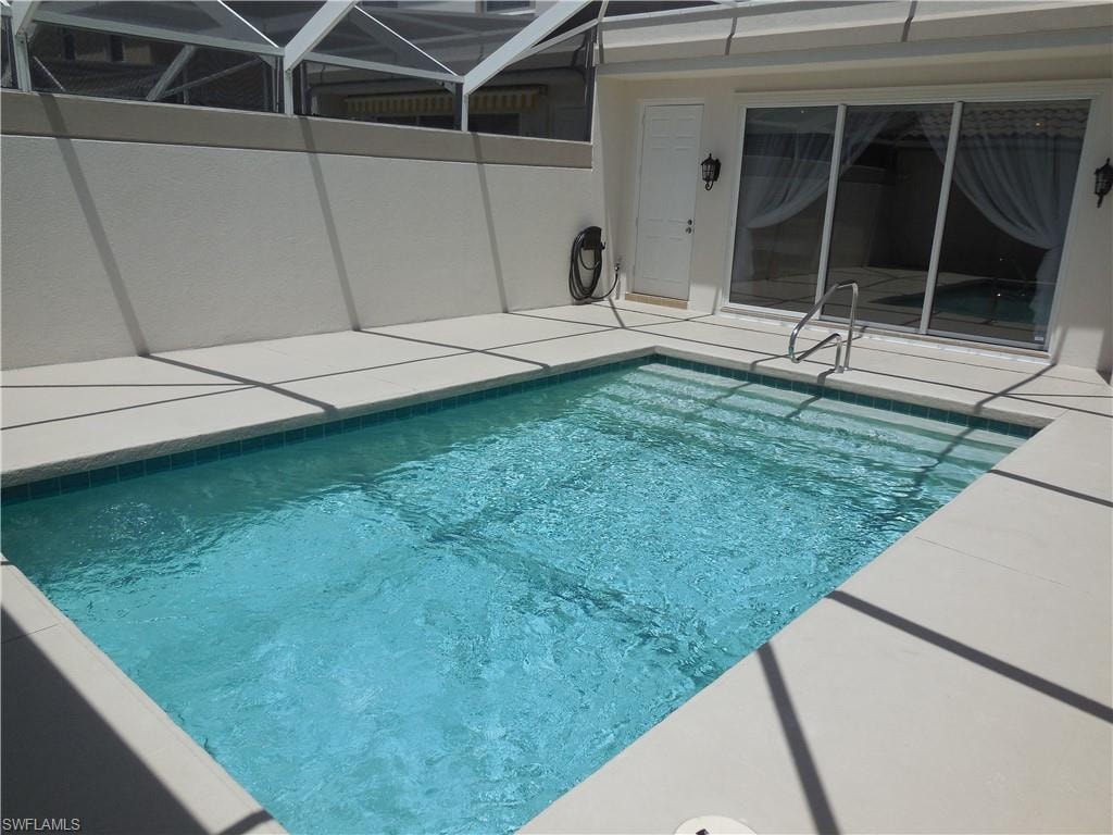 Swimming pool with a patio and glass enclosure