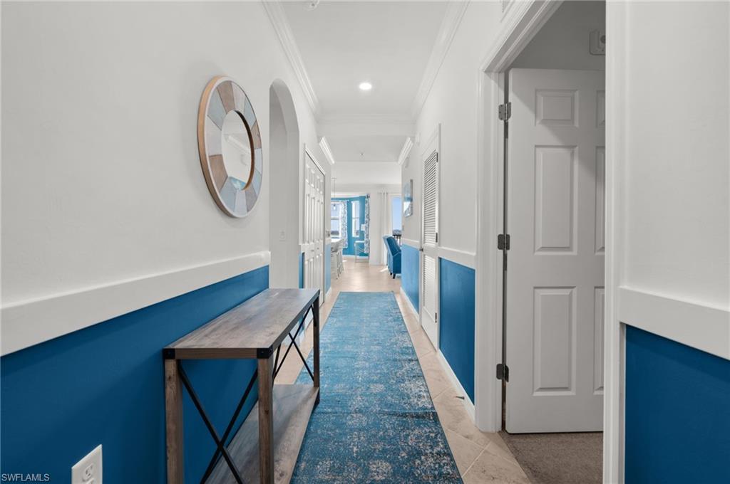 Entryway featuring two-tone wall treatment, crown molding, and tiled flooring