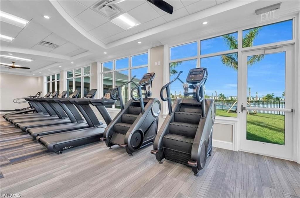 Fitness center featuring a row of treadmills and two stair climbers on patterned carpet flooring