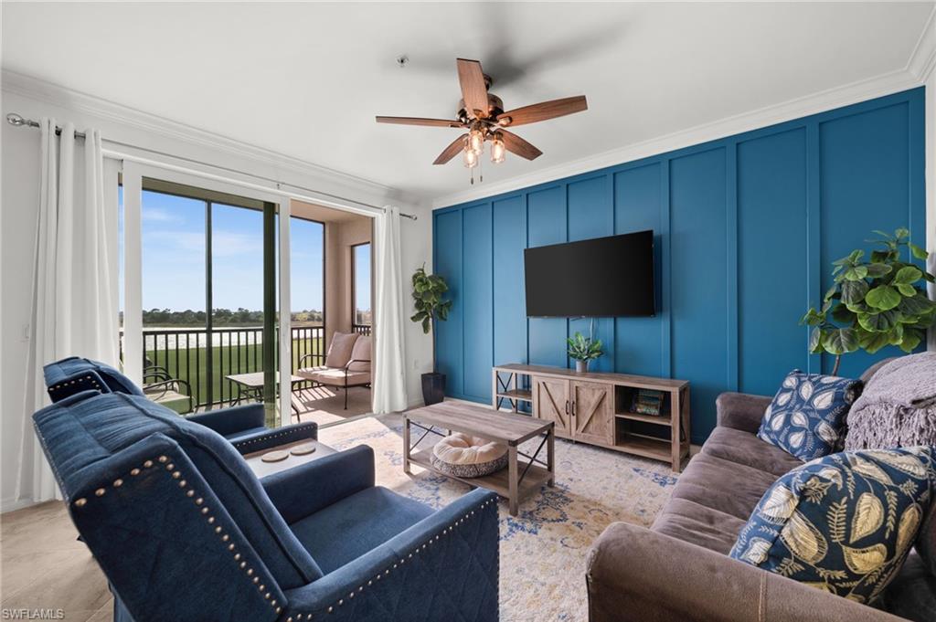 Living area featuring a floor-to-ceiling accent wall with vertical paneling, crown molding, and a ceiling fan with light fixture