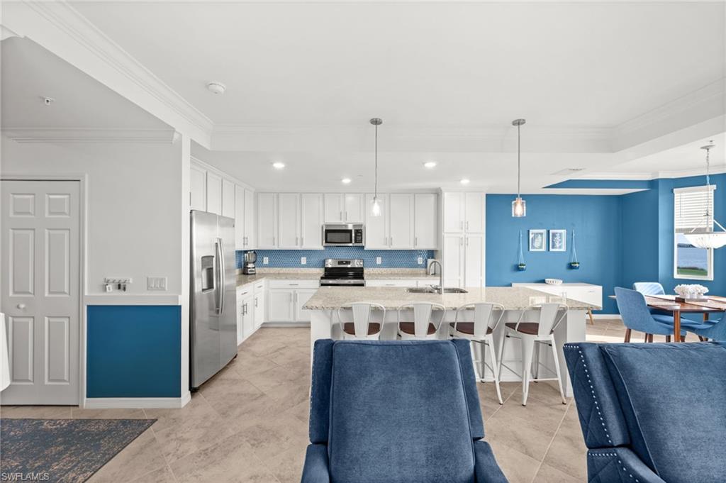 Spacious kitchen featuring white cabinetry, stainless steel appliances, and a light-colored countertop
