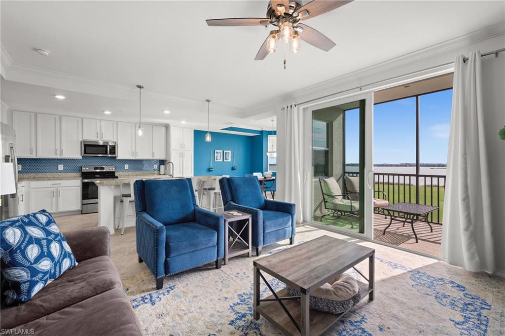 Open-concept living space with a contemporary kitchen, sliding glass doors, crown molding, and a ceiling fan with integrated lighting