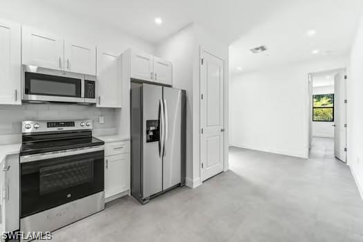 Kitchen #2 in Second Unit featuring stainless steel appliances, light countertops, concrete floors, white cabinetry, and recessed lighting