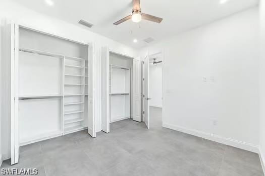 Bedroom on main entrance side with finished concrete floors, two custom closets, ceiling fan, and recessed lighting