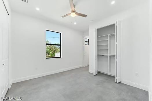 Primary Bedroom on main entrance sidewith concrete floors, recessed lighting, ceiling fan, and a custom closet