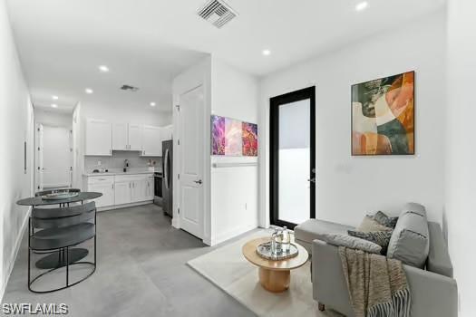 Living area (Virtual Staged) in Second Unit featuring finished concrete floors and recessed lighting