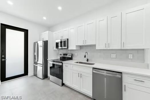 Kitchen#1 featuring stainless steel appliances, white cabinets, light countertops, recessed lighting, and backsplash