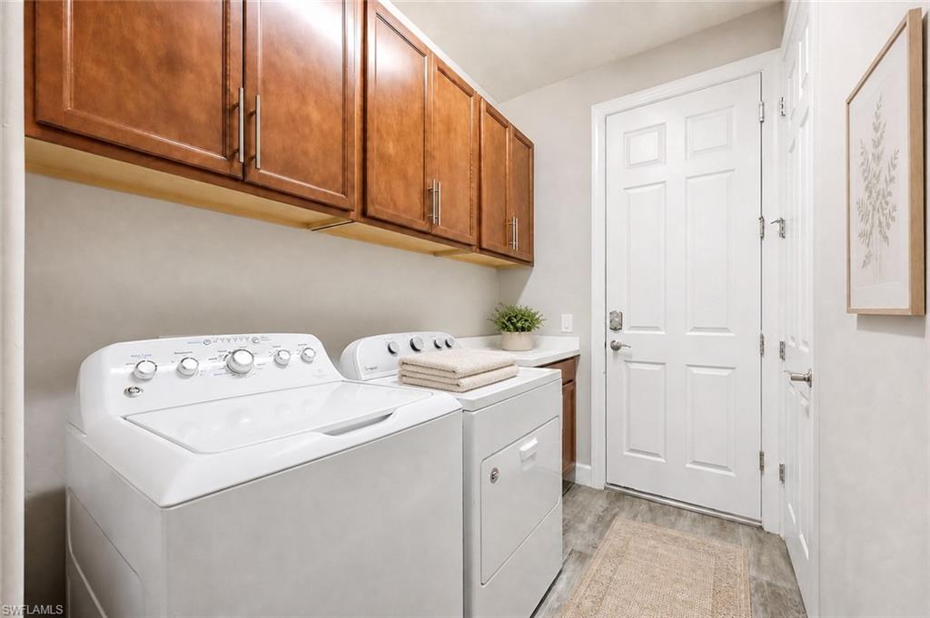Dedicated laundry area featuring wood-finish cabinetry, a white countertop, and wood-finish flooring