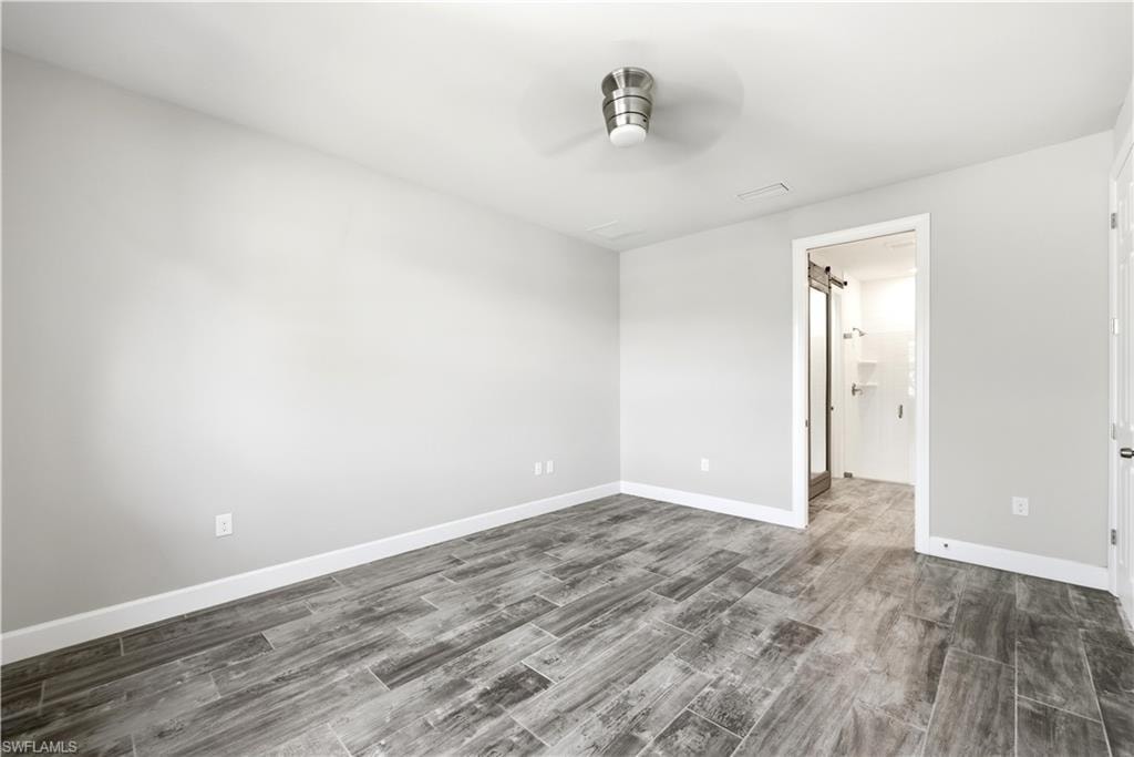Spacious room featuring wood-look tile flooring, light gray wall paint, and white baseboards