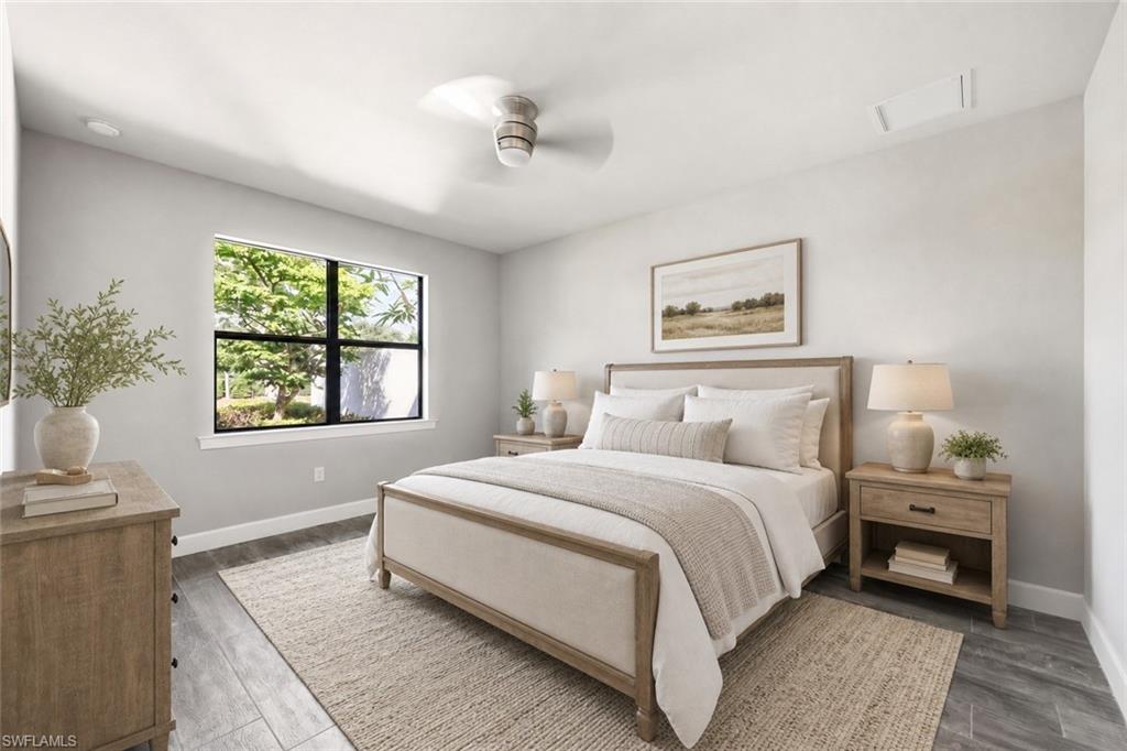 Spacious room featuring a large window with exterior landscaping, wood-finish flooring, a ceiling fan, and recessed lighting
