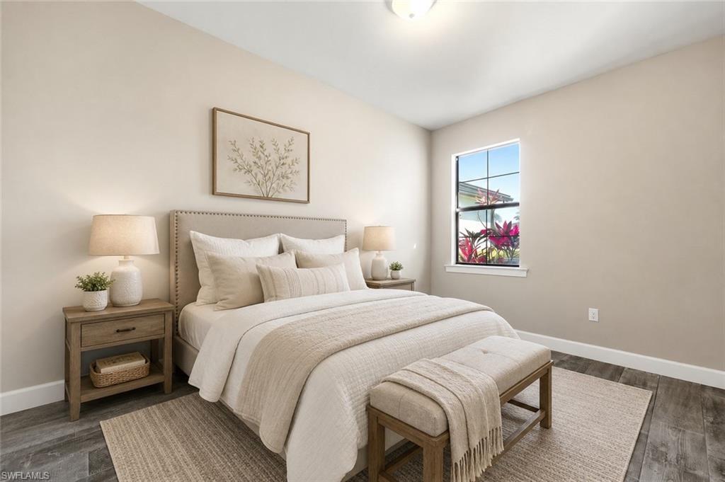 Neutral-toned room featuring wood-finish flooring, a single window with white trim, and a ceiling light fixture