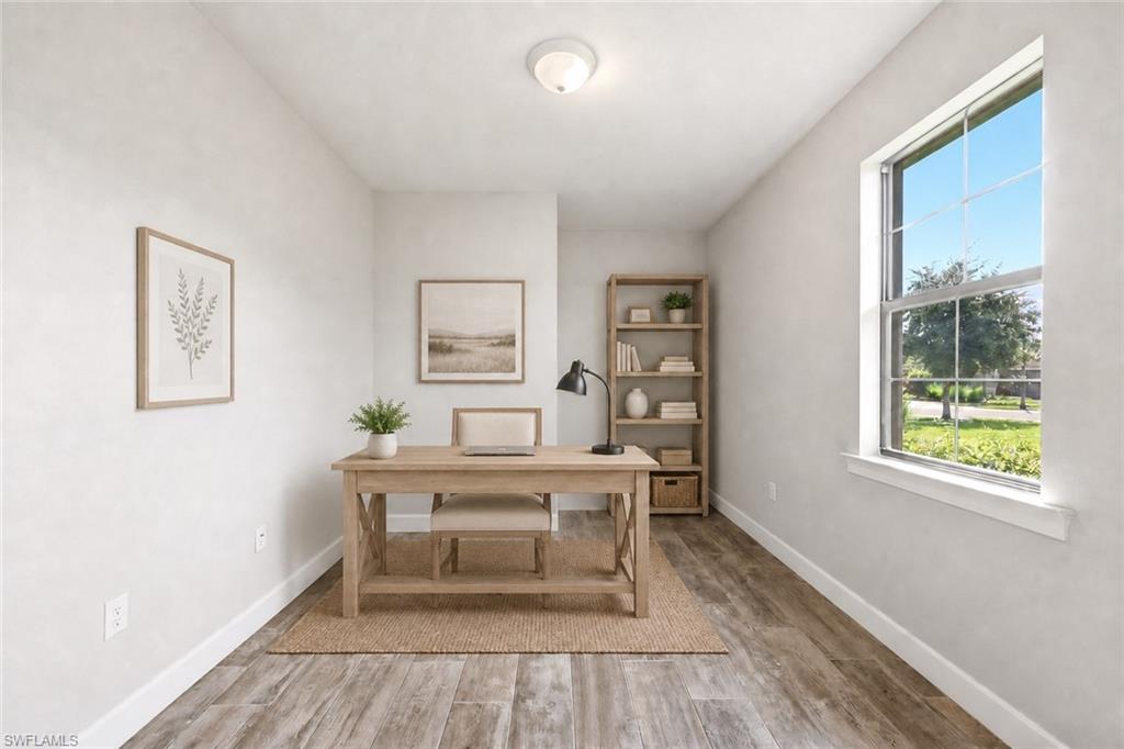 Versatile interior space featuring wood-finish flooring, a large window with grid pattern, and neutral wall tones