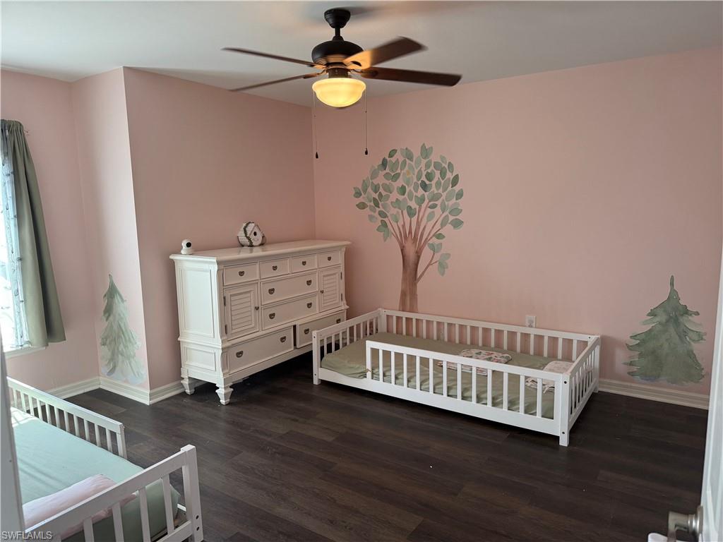 Spacious room featuring wood-finish flooring and a ceiling fan with integrated lighting