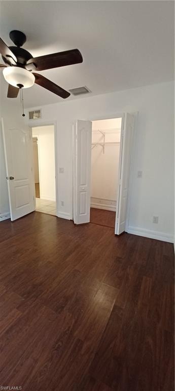Spacious room Master Closet featuring wood-finish flooring, a ceiling fan with integrated lighting, white baseboards, and a bi-fold closet with shelving